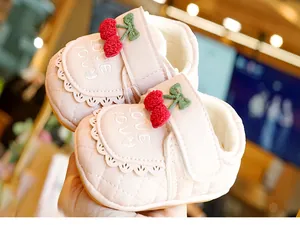 Détails macro de chaussures bébé roses avec doublure en polaire et broderie cerise