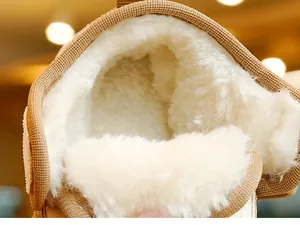 Close-up of thick white faux fur lining and brown knitted edge of winter baby boots
