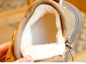 Detailopname van de dikke witte pluche voering en rits van de bruine baby-winterschoenen