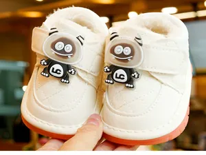 Detail of white infant walking shoes with warm fleece lining and orange rubber sole