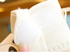Macro detail of Velcro strap and plush collar on white leather baby walking shoes