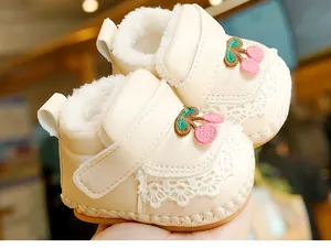 Detail of warm baby shoes with lace trim, cherry embroidery, and thick faux fur lining