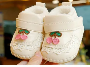 Detail of cream baby walking shoe with cherry embroidery, fleece lining and lace trim