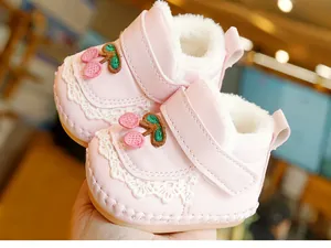 Detail of pink baby walking shoes with cherry embroidery and soft faux fur lining
