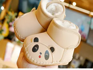 Close-up of baby snow boots featuring panda design, thick faux fur lining and velcro strap