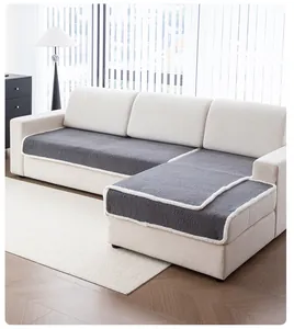 Detail of dark gray faux shearling sofa cover with white plush edging on L-shaped sofa
