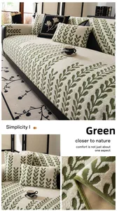 Détail de la housse de canapé en peluche blanche avec motifs de feuilles vertes et coussins