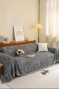 Detail of grey textured sofa cover with tassels and 360-degree full wrap design