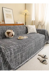 Detail of grey chenille sofa cover with woven texture and fringe trim for home decor