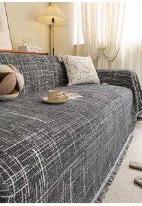 Detailed texture of dark grey woven sofa cover with decorative handmade fringe edges