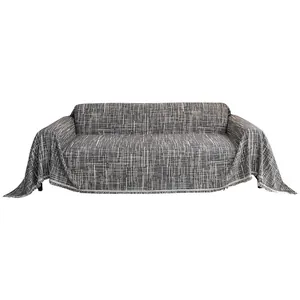 Gray textured sofa cover with decorative fringe on a white background