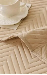 Close-up of khaki quilted sofa cover with geometric patterns and soft brushed texture