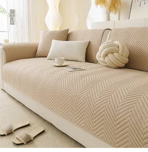 Close-up of khaki quilted sofa cover with herringbone pattern in a cozy home setting