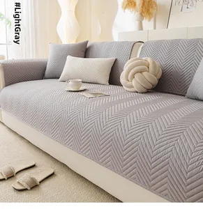 Macro view of light gray quilted sofa cover with premium herringbone texture and thick fabric