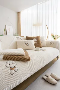 Detail of plush sofa cushion featuring white cartoon puppy embroidery and chevron texture
