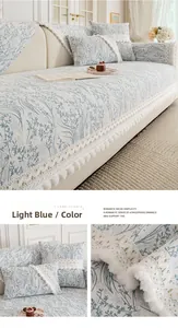 Detailed close-up of light blue floral washed cotton sofa cover with lace and pom-pom trim