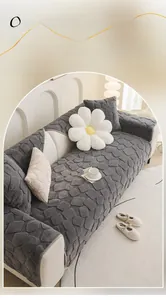 Detail of dark grey rabbit faux fur sofa cover with textured square embossed patterns