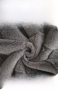 Close-up of thick grey faux rabbit fur fabric showing soft plush texture and high density