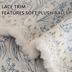 Chenille sofa cover with blue plant prints, delicate lace edges and white pompom trim