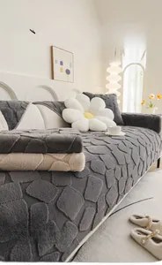 Detail of dark grey rabbit faux fur sofa cover with textured square quilting and plush feel