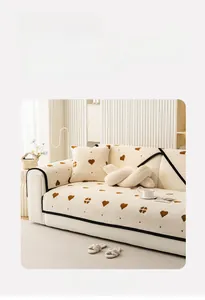 Close-up of thick plush beige sofa cover with brown heart patterns and black piped edges