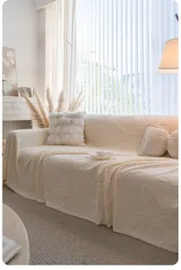 Detail of cream plush sofa cover featuring 3D butterfly embossed pattern and fringe edges