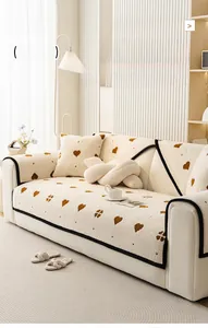 Detail of plush cream sofa cover with brown heart patterns and soft flannel texture