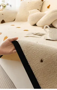 Detail of plush cream sofa cushion with brown heart pattern and non-slip backing