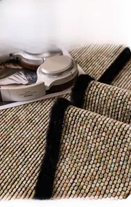 Detail of pixel-pattern chenille sofa cover with soft black plush border and woven texture