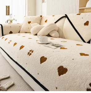 Close-up of thick plush beige sofa cover with brown embroidered hearts and soft texture