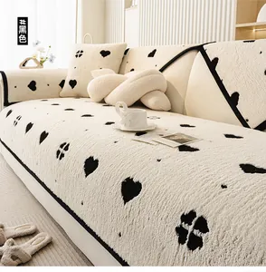 Detail of soft plush sofa cover featuring black heart patterns and contrast piping