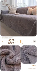 Close-up of light gray sherpa fleece sofa cover with embossed butterfly pattern
