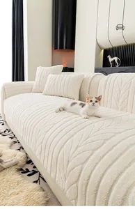 Detail of soft cream chenille sofa cover with embossed leaf patterns and matching pillow