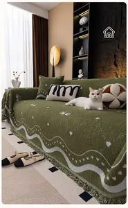 Detail of dark green velvet sofa cover with white heart patterns and elegant tassels
