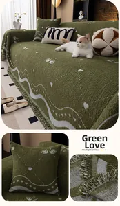 Detail of green chenille sofa throw with white wave patterns, hearts, and elegant tassels