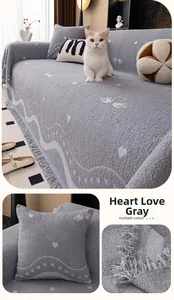 Macro detail of grey textured knit sofa throw with heart patterns and white fringe edges