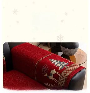 Detail of red Christmas chenille sofa cover with reindeer embroidery and golden edges
