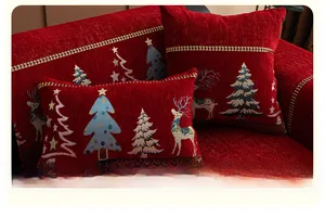 Detail of red Christmas chenille sofa cushion with reindeer and tree jacquard patterns
