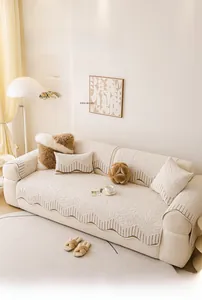 Close-up of cream single-sided fleece sofa cover with wavy edges and dark brown piping