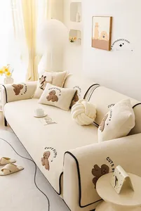 Detail of soft cream teddy fleece sofa cover with cute puppy embroidery and black piping