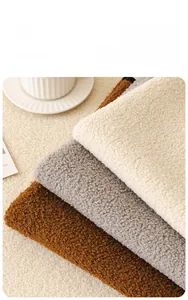 Detail of plush teddy fleece sofa cushions in white, grey, and brown textured fabric