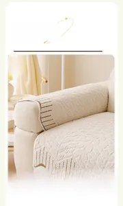 Close-up of cream velvet sofa armrest cover with brown striped edges in modern home decor