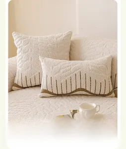 Detail of cream plush velvet sofa pillows with brown wavy textured geometric patterns