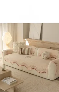 Detail of cream sofa cover with red wavy edges and textured non-slip knitted fabric