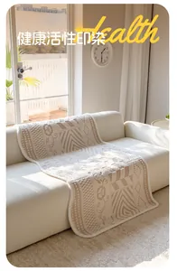 Close-up of beige woven sofa cover featuring geometric floral jacquard and edge binding