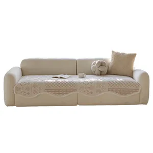 Elegant cream quilted sofa cover with floral patterns and scalloped edges for modern decor