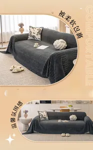 Close-up of thick dark grey sofa cover with geometric knit texture and soft fringe edge