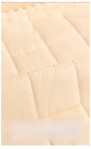 Detail of anti-slip silicone particles on the back of a beige sherpa sofa cover mat