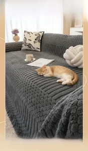 Detail of thick dark grey plush sofa cover with textured pattern and sleeping cat