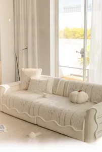 Close-up of irregular cream-colored sofa cover with embroidered velvet texture